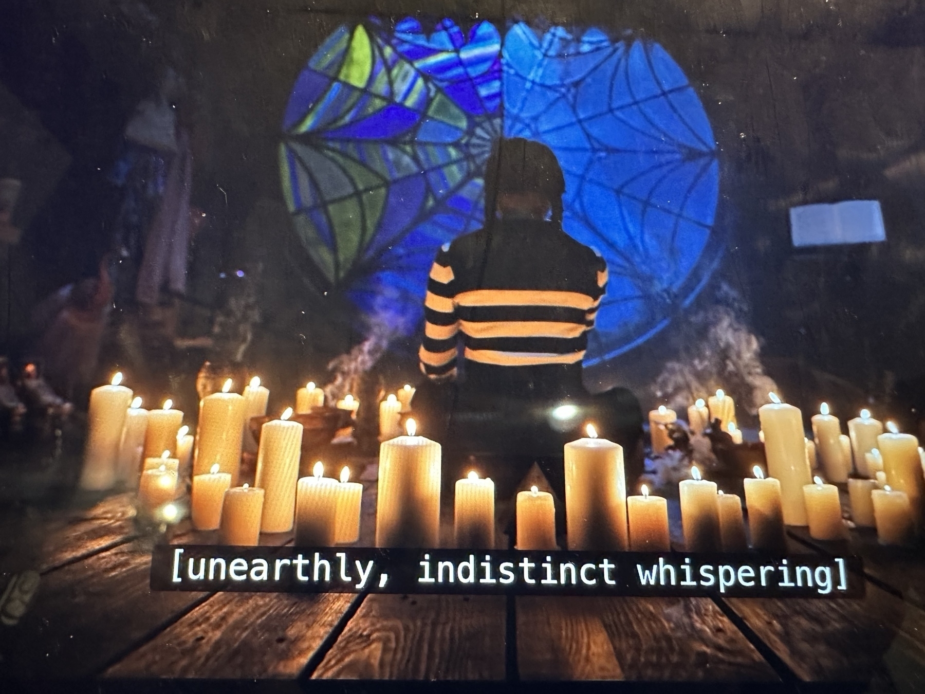 Still from "Wednesday" with subtitle [unearthly, indistinct whispering]